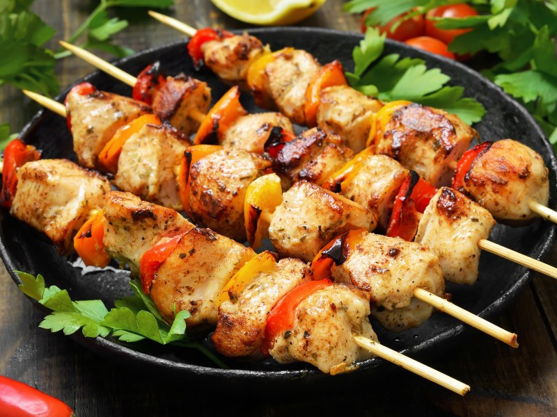 Gegrillte Hähnchenspieße auf einem Teller.