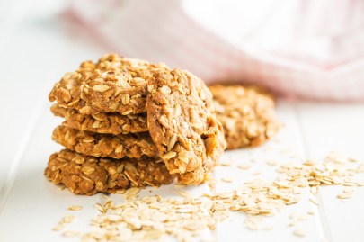 Ein Stapel Bananen-Haferflocken-Kekse, drumherum Haferflocken, Nahaufnahme.