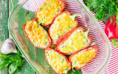 Gefüllte Paprikas mit Feta und Reis in einer durchsichtigen Auflaufform. In der Draufsicht.