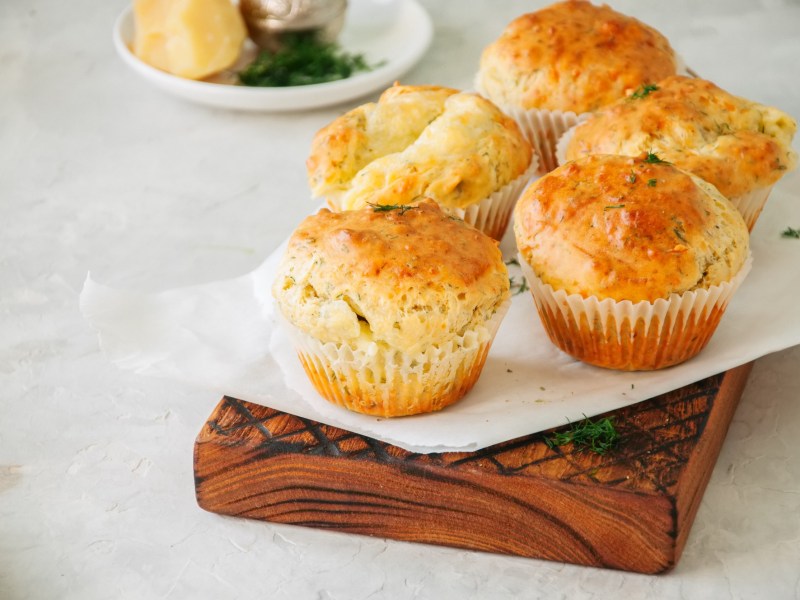 Hüttenkäse-Muffins mit Zucchini auf einer weißen Papierunterlage.