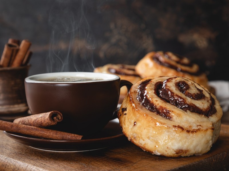 Kaffee-Zimtschnecken neben einer Kaffeetasse.