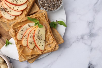Erdnussbutter-Apfel-Sandwich auf einem Teller.