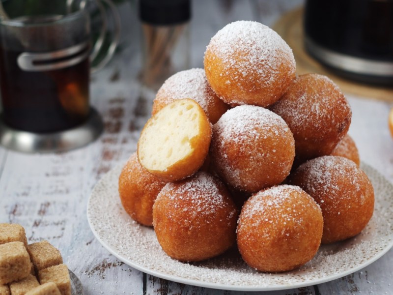Ein Berg Quarkbällchen aus der Heißluftfritteuse auf einem Teller.