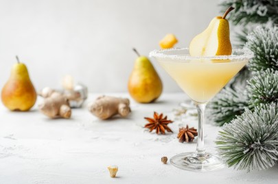 Ein Glas Birnen-Martini mit Birnen im Hintergrund und winterlichen Gewürzen