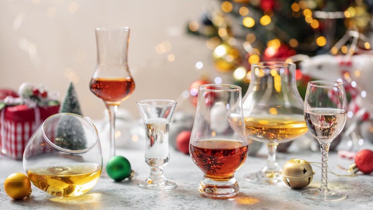 Liköre zum Verschenken: einige Likörgläser auf einem weihnachtlich gedeckten Tisch.