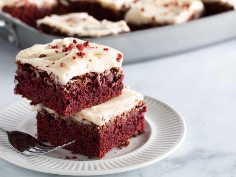 Zwei Red Velvet Brownies, die auf einem Teller übereinander liegen.