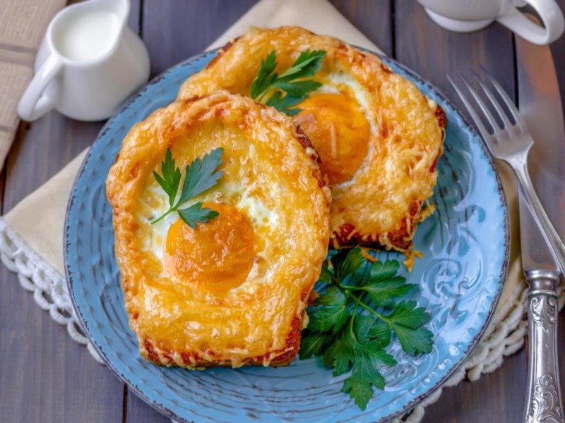 Zwei Spiegelei-Toasts auf einem blauen Teller.