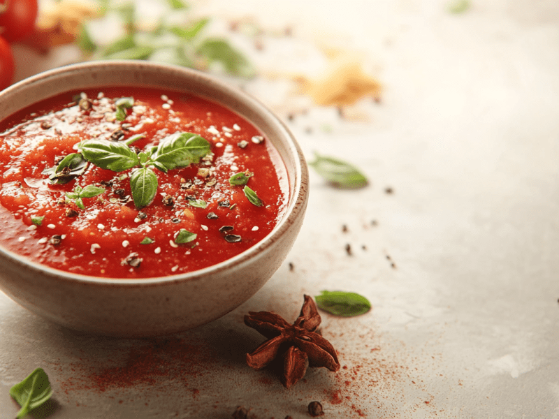 Eine kleine Schüssel Tomaten-Chutney, daneben Zutaten.
