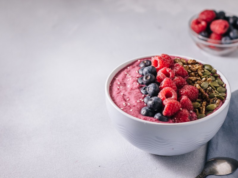 Eine Açai-Bowl, getoppt mit frischen Früchten, Kernen und Nüssen.