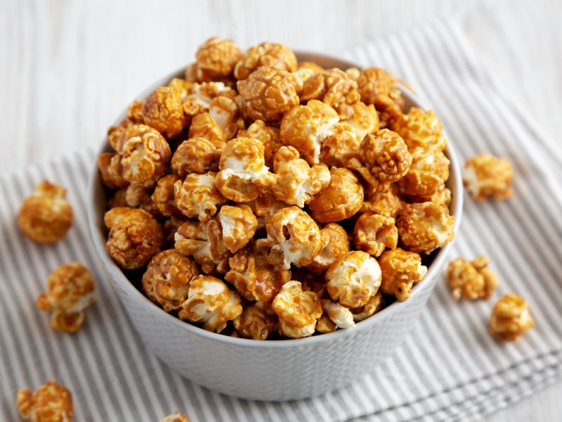Schale mit Karamell-Popcorn auf gestreiftem Tischtuch