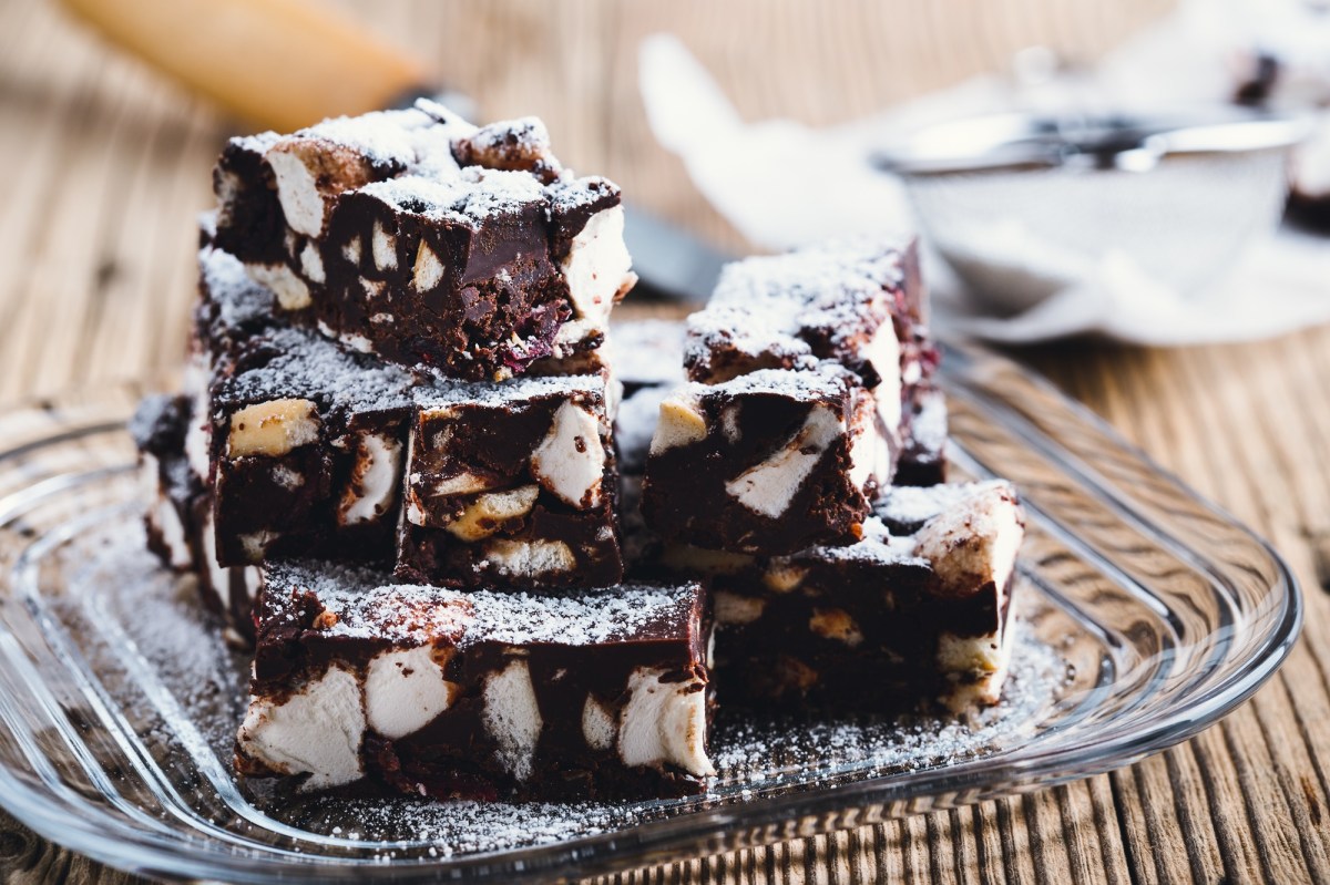Einige Stücke Rocky-Road-Schokoriegel mit Marshmallows auf einem Glasteller.