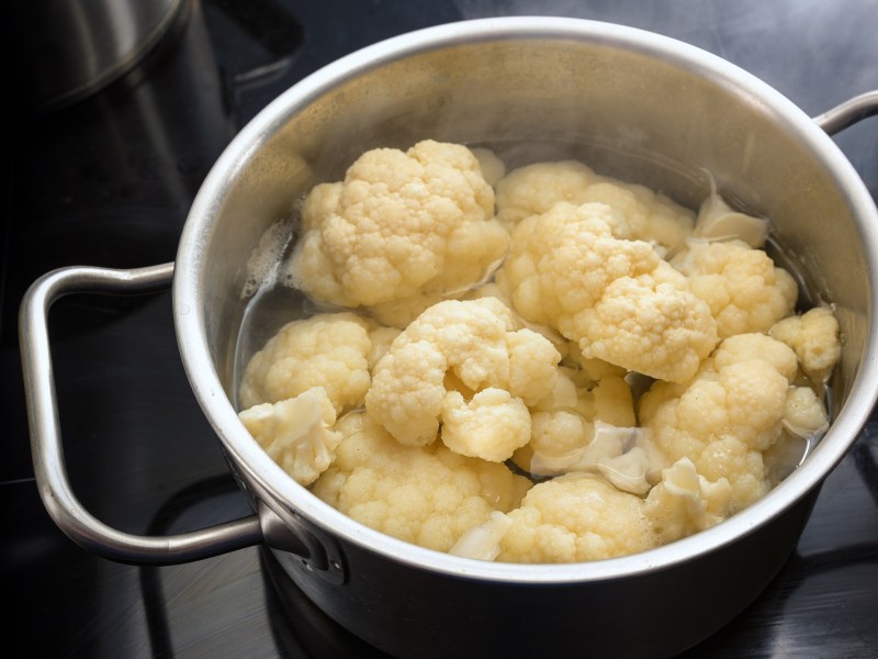 Blumenkohl kochen: Blumenkohlröschen in einem Topf mit Wasser.