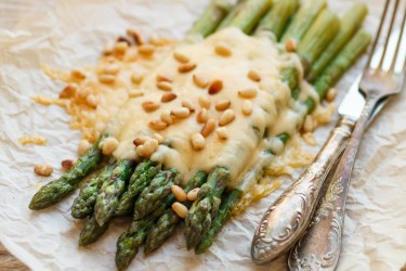 Grüner Spargel mit Käse und gerösteten Pinienkernen.