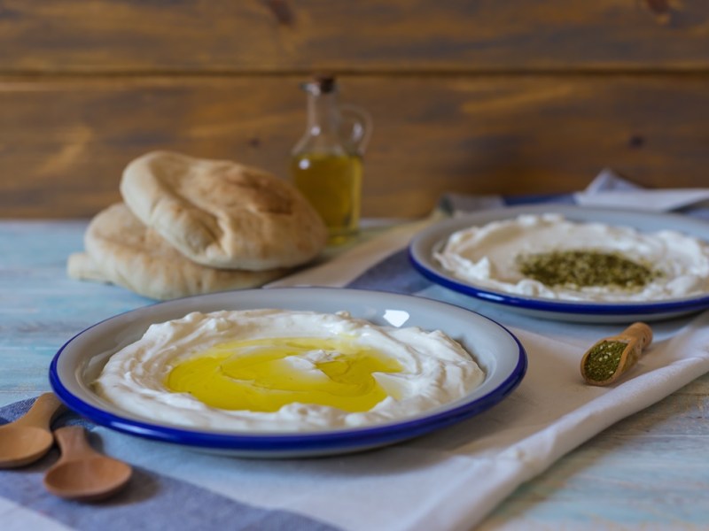 Labneh selbst machen: zwei Teller Labneh stehen nebeneinander, einer ist mit Olivenöl beträufelt.