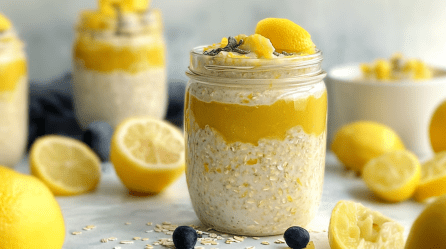 Lemon Curd Overnight Oats in Einmachgläsern. Drumherum liegen Zitronen.