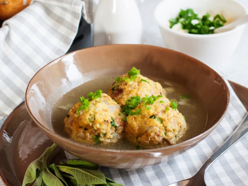 3 Pilzknödel auf einem Teller mit Petersilie bestreut, Nahaufnahme.
