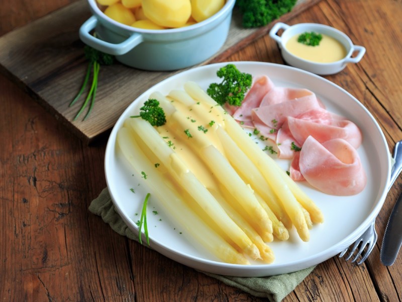 Teller mit Spargel mit Schinken und Sauce hollandaise