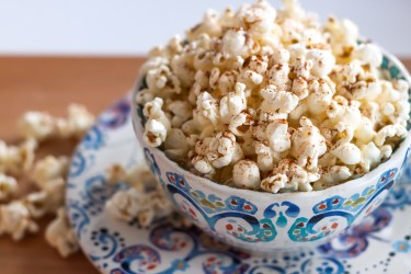 Eine gemusterte Schale mit Zimt-und-Zucker-Popcorn.