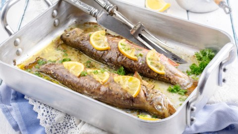 Zwei Backofen-Forellen in einer silbernen Ofenform.