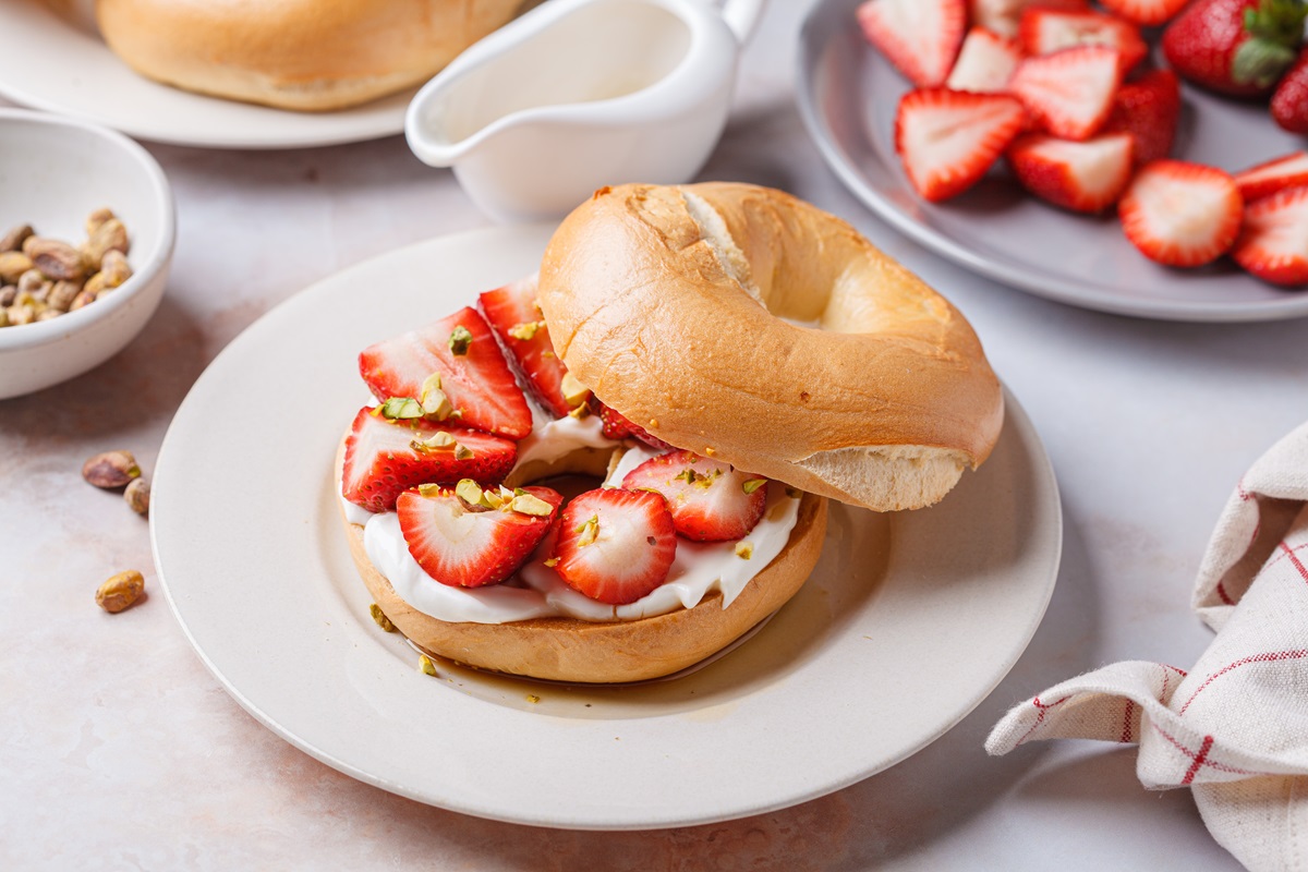 Ein Erdbeer-Ricotta-Bagel auf einem weißen Teller.