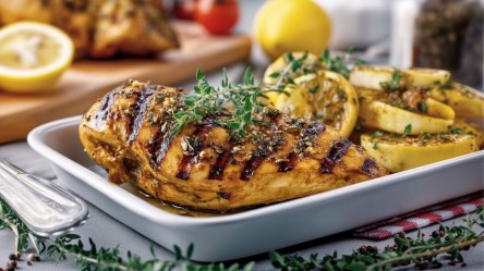 Gegrilltes Zitronenhähnchen auf einem eckigen Teller.