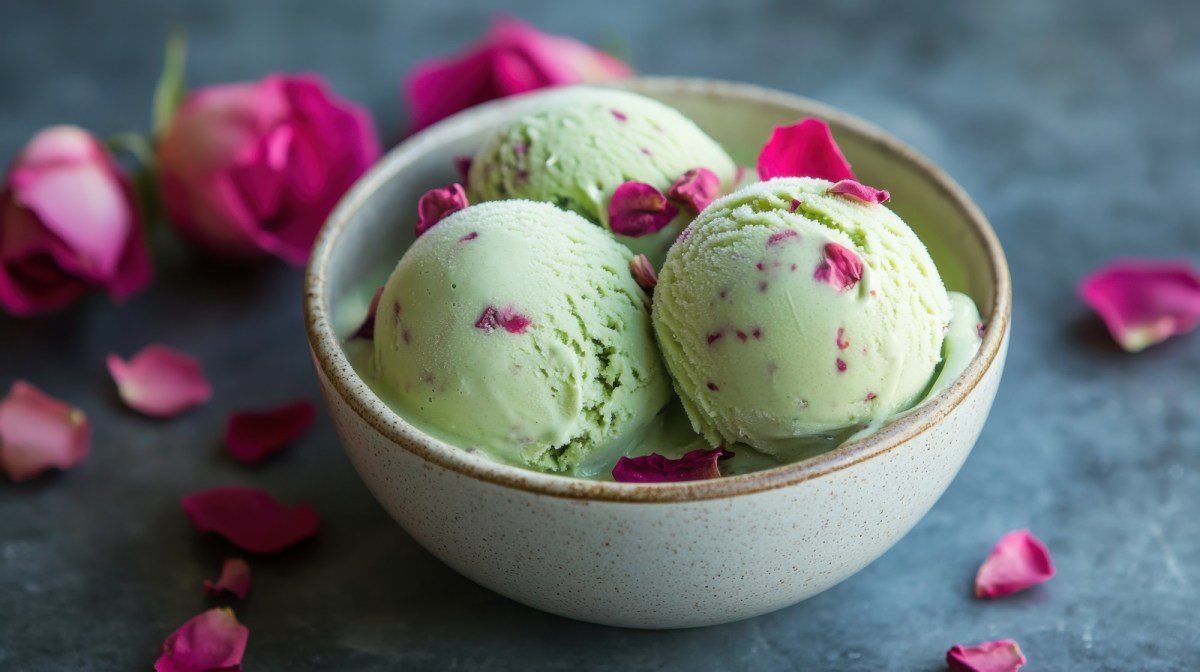 Drei Kugeln Pistazien-Rosen-Eis in einer hellgrünen Schüssel.