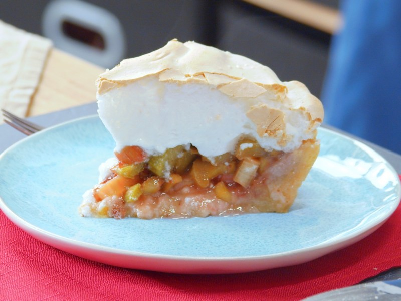 Ein Stück Rhabarbertarte mit Baiser au feinem Teller.