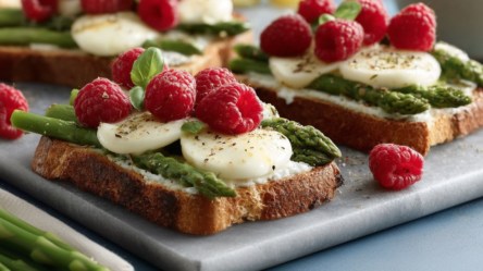 Mehrere Spargel-Himbeer-Toasts auf einem Brett.