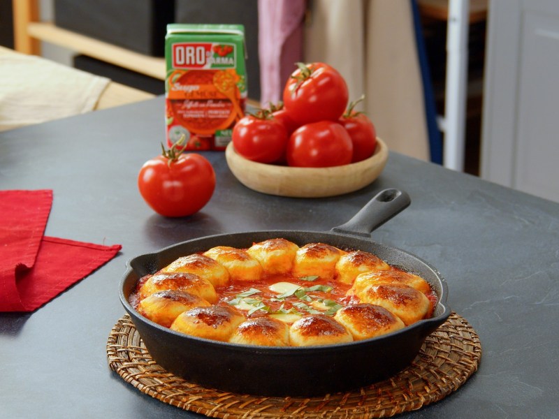 Zupfbrötchen mit Tomatensugo in einer gusseisernen Pfanne.