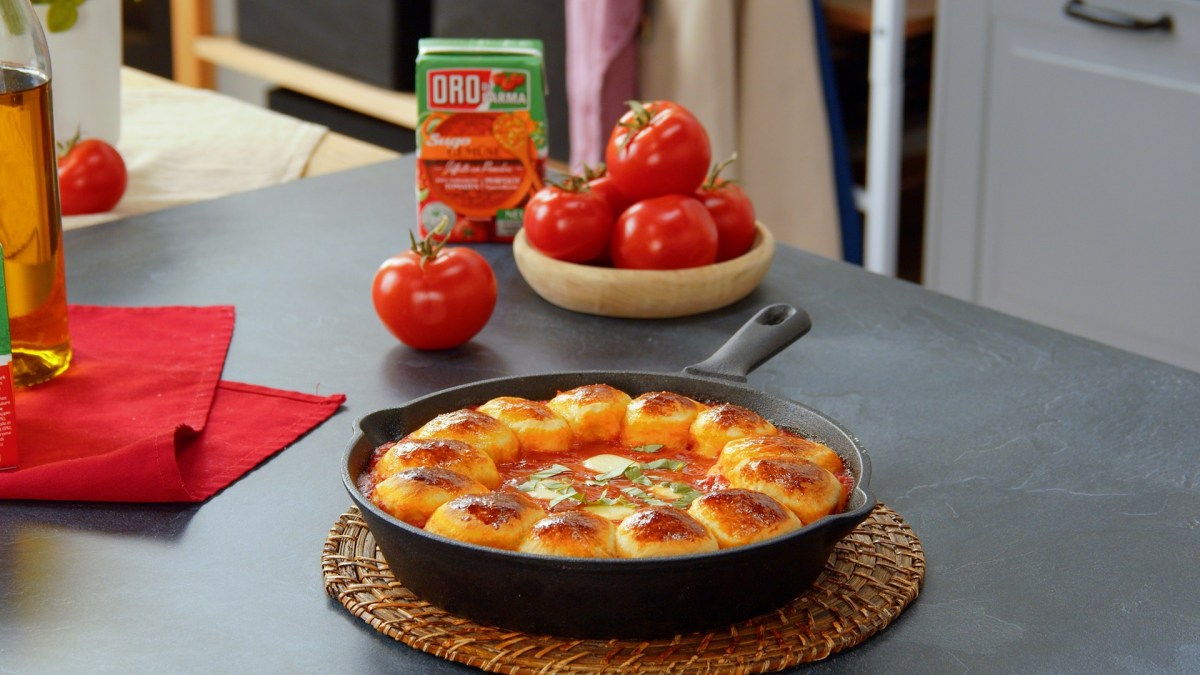 Zupfbrötchen mit Tomatensugo in einer gusseisernen Pfanne.