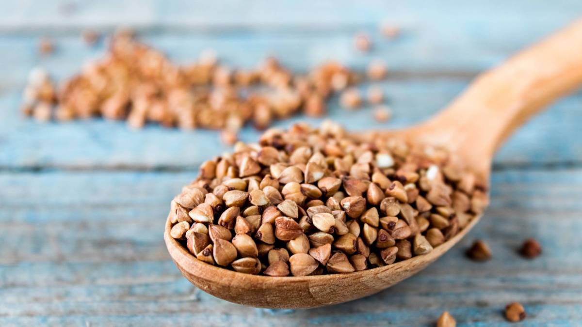 Ist Buchweizen gesund? Buchweizenkörner auf einem Holzlöffel.