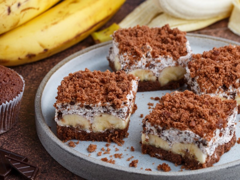 Vier Stücke von Maulwurfkuchen vom Blech, angerichtet auf einem Teller.