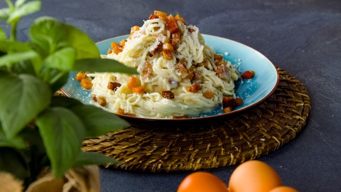 Italienische Spaghetti Carbonara auf einem blauen Teller.