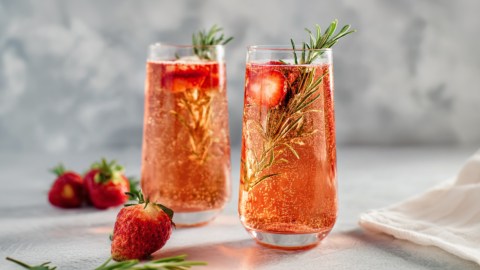 Zwei Gläser würziger Erdbeer-Sekt mit Rosmarin.