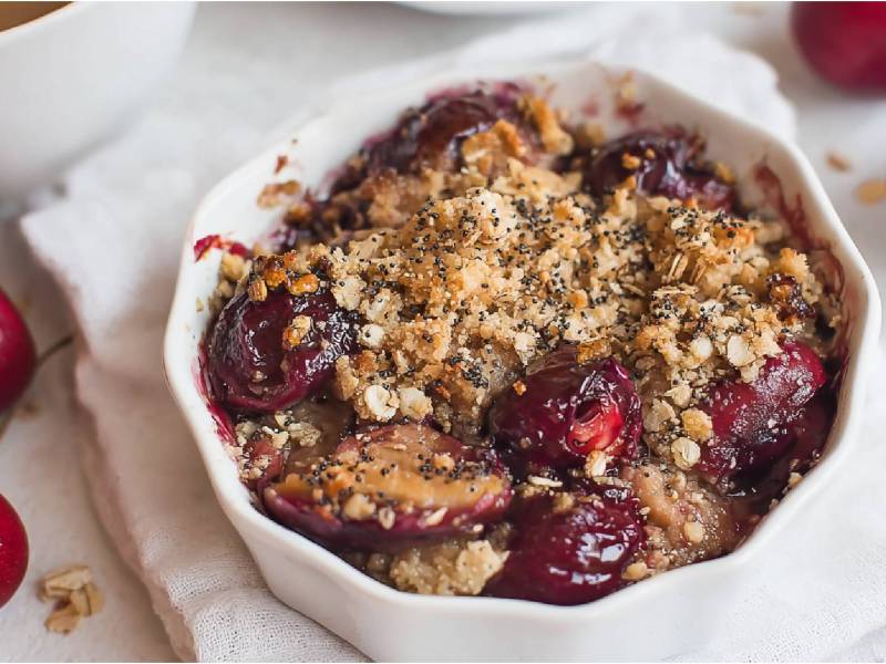 Kleine Auflaufform mit Frühstücks-Crumble mit Mohn und Kirschen