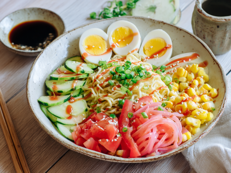Eine Schüssel mit Hiyashi-Chuka. Links neben der Schüssel liegen Stäbchen sowie eine Schlae Sojasoße.