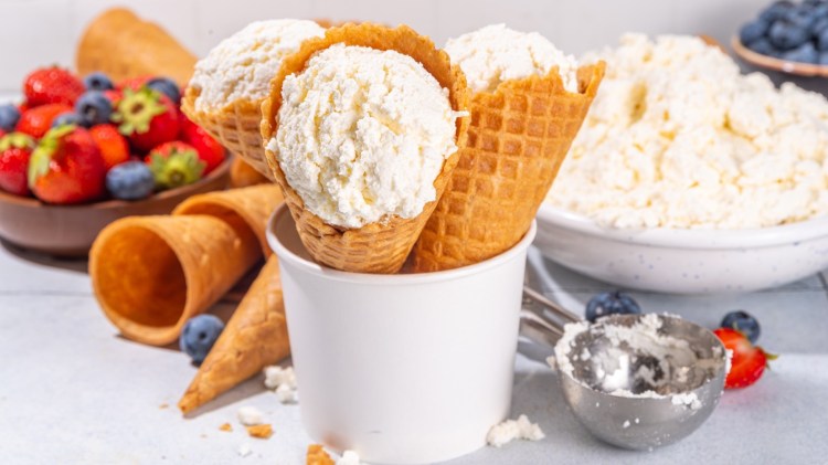 Mehrere Kugeln Hüttenkäse-Eis in Waffeln in einem Becher.