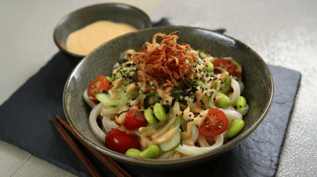 Eine Schale kalter Udon mit Sesamsoße auf einer Schieferplatte.