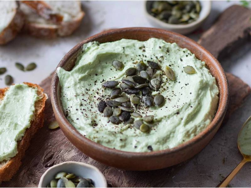Schale mit Kürbiskern-Quark-Aufstrich und Brot daneben