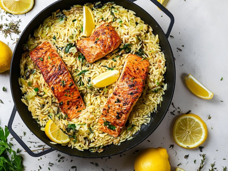 Eine Orzo-Zitronen-Pfanne mit Lachs in der Draufsicht.