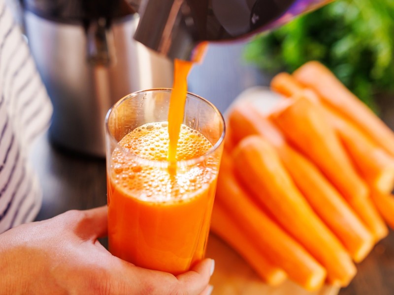 Philips Series 3000 Entsafter: Eine Person füllt Karottensaft in ein Glas.