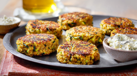 Quinoa-Bratlinge mit Zucchini und Feta, serviert auf einem Teller.