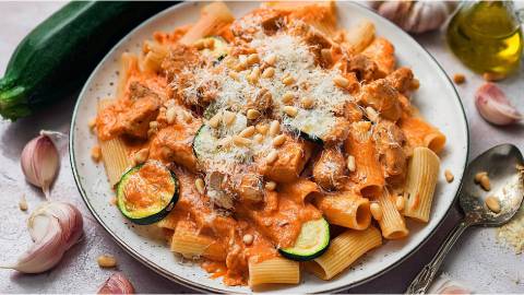 Teller mit Tomaten-Zucchini-Pasta mit Hühnchen