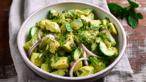 Eine Schale Avocado-Gurkensalat mit roten Zwiebeln.