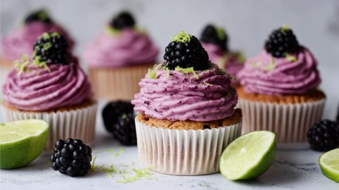 Mehrere Brombeer-Limetten-Cupcakes.