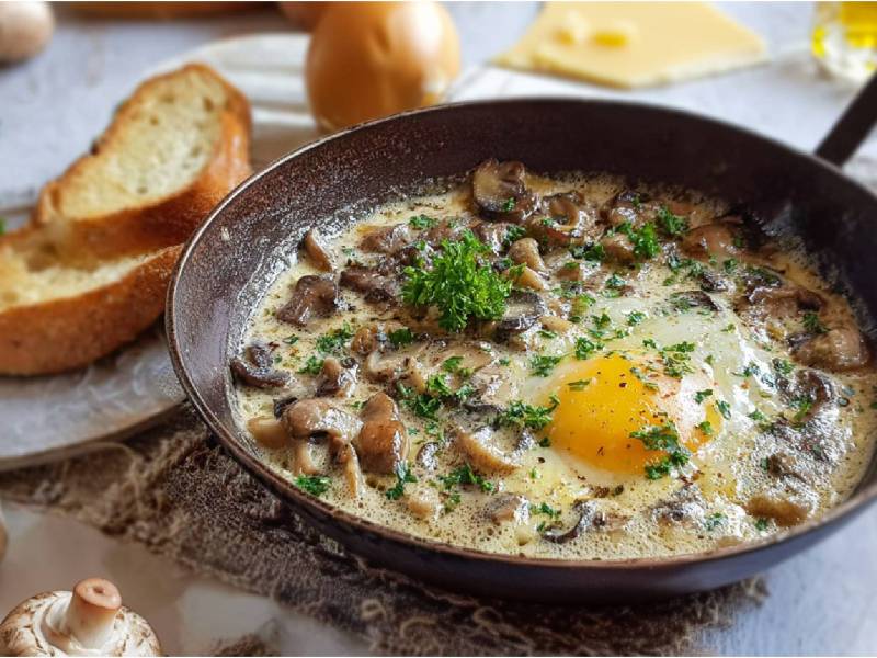 Rustikale Pfanne mit Champignonpfanne mit Ei, Brot daneben