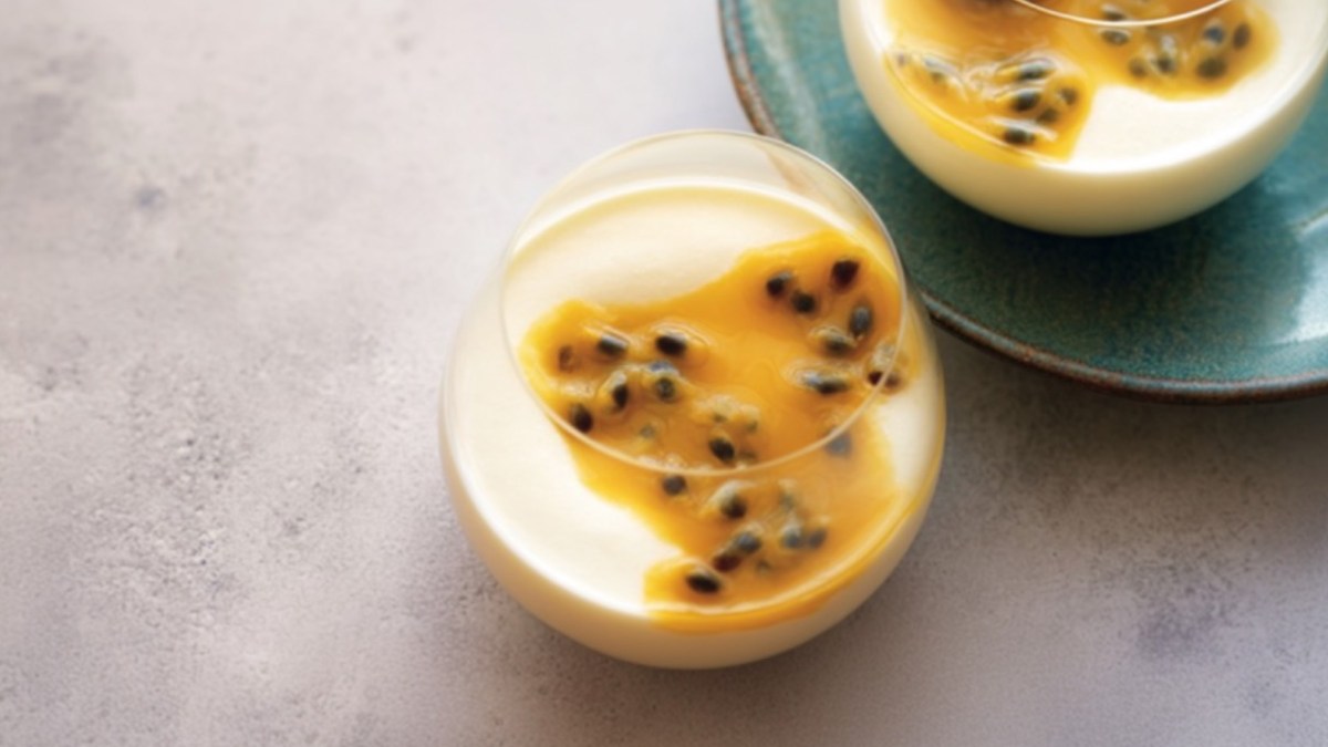 Ein Glas Crème-fraiche-Mousse mit Maracujasoße in der Draufsicht.