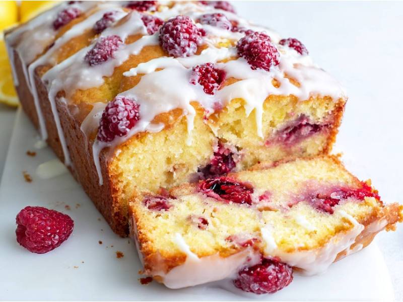 Himbeer-Zitronenkuchen aus der Kastenform auf einem Küchenbrett