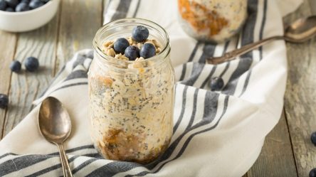 Ein Glas mit Kefir Overnight Oats, serviert mit Blaubeeren.
