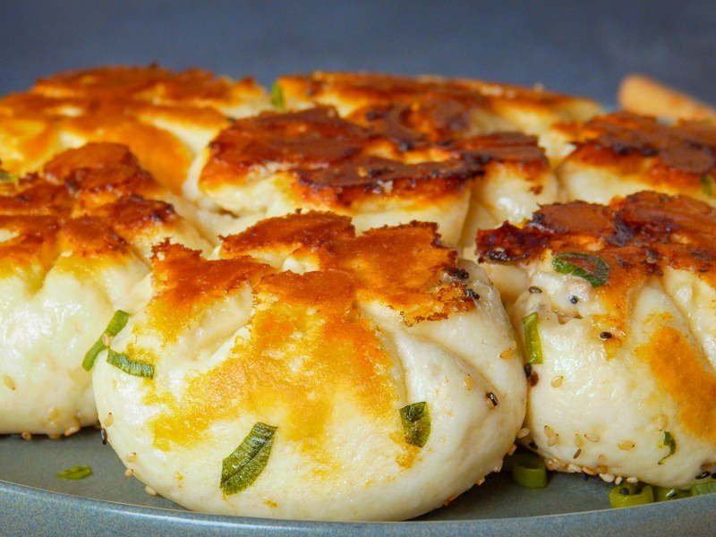 Knusprige Dumplings auf einem grauen Teller.